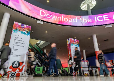 Interior view of Fira Barcelona, the official venue for ICE 2025, with event banners and attendees arriving.