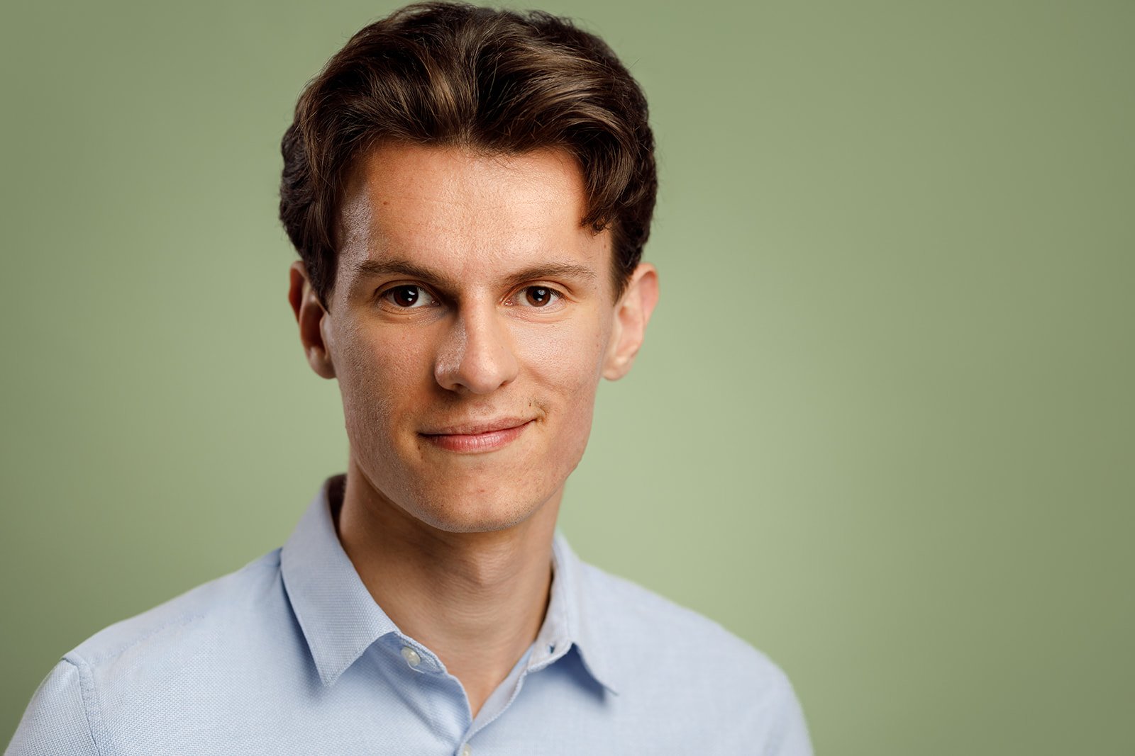 Positive Studio Portrait of a Smiling Man in Minimalist Style Smiling man in dark minimalist clothing, photographed in studio – focus on facial expression and positive energy