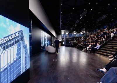 Speaker on stage during Revolut London finance event presentation with audience